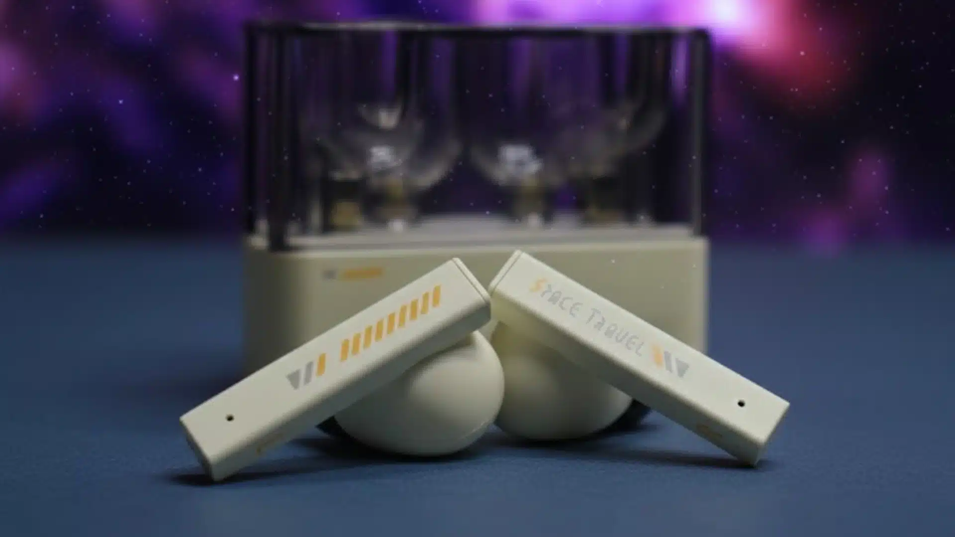 Moondrop Space Travel wireless earbuds placed in front of a transparent charging case with a soft blurred background