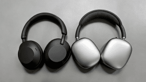 Black and silver over-ear headphones placed side by side on a gray surface.