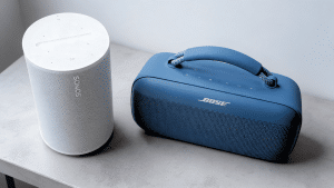 White and blue portable speakers placed on a tabletop against a light background.