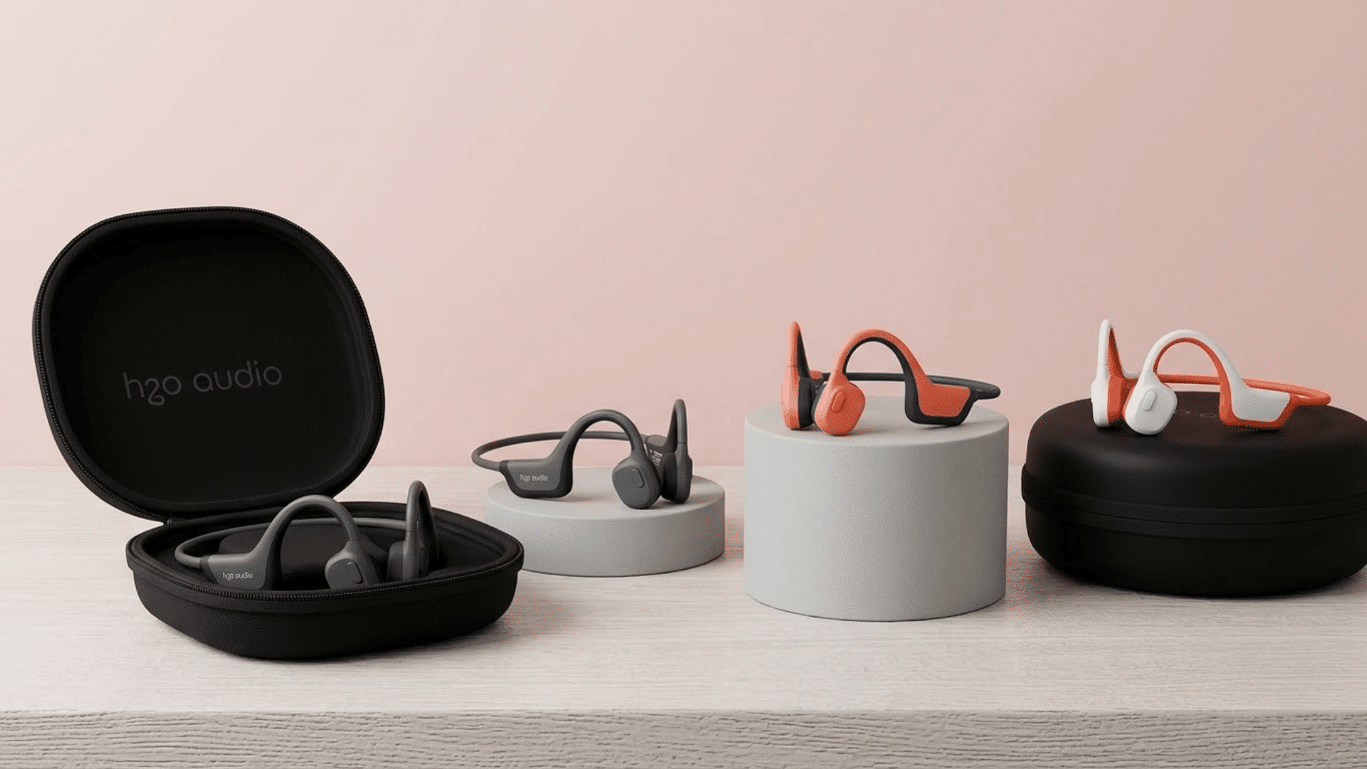 Bone conduction headphones displayed with carrying cases on a minimalist tabletop setup.